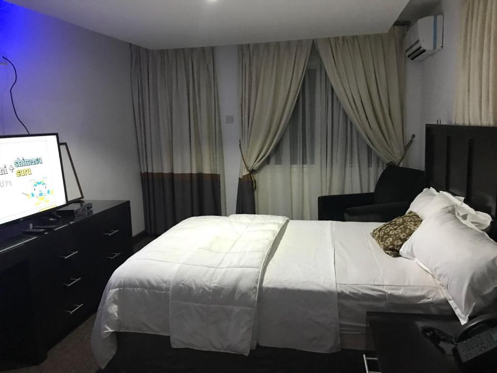 Cette chambre comprend un lit et une télévision à écran plat. dans l'établissement Hotel Cabenda, à Freetown