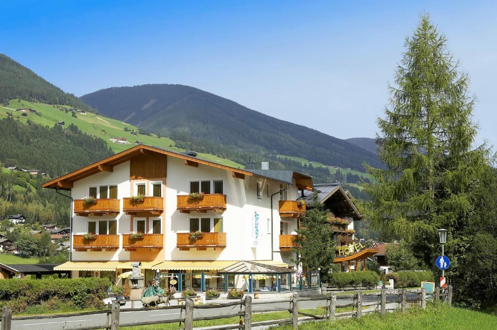 un bâtiment avec balcon et clôture à côté d'une montagne dans l'établissement Aparthotel Garni Schranz, à Wald im Pinzgau