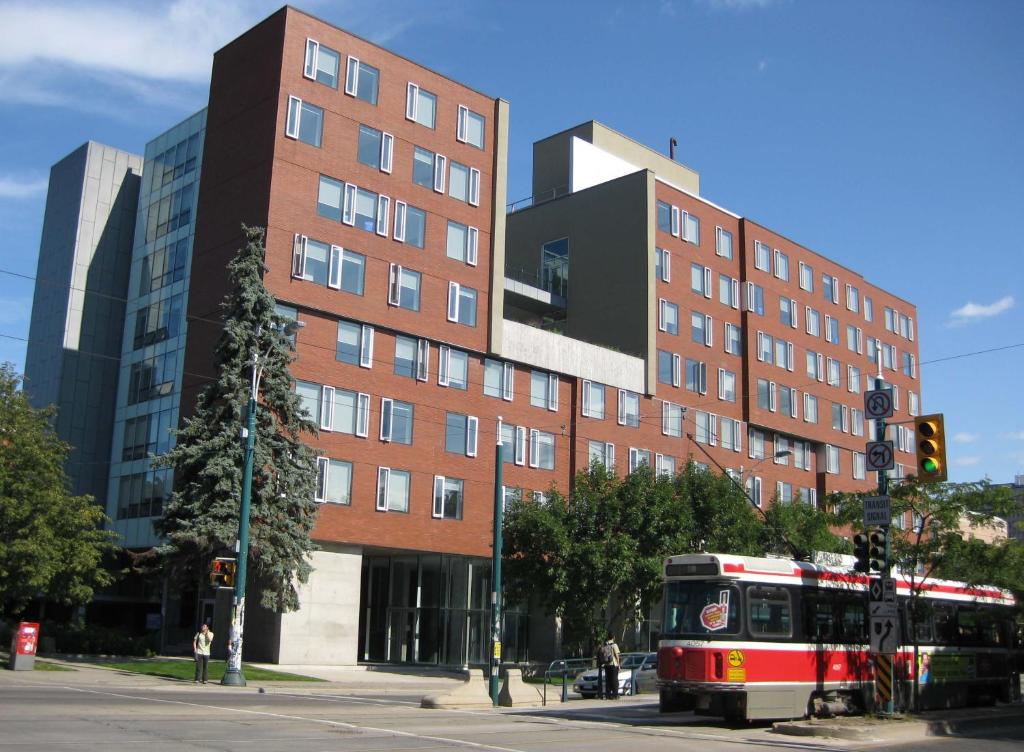 a bus on a street in front of a building at University of Toronto-New College Residence-45 Willcocks Residence in Toronto