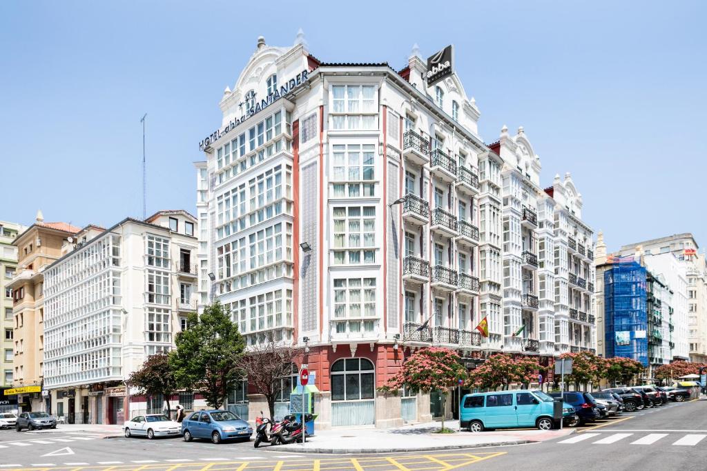 un grand bâtiment blanc dans une rue de la ville avec des voitures dans l'établissement Abba Santander, à Santander