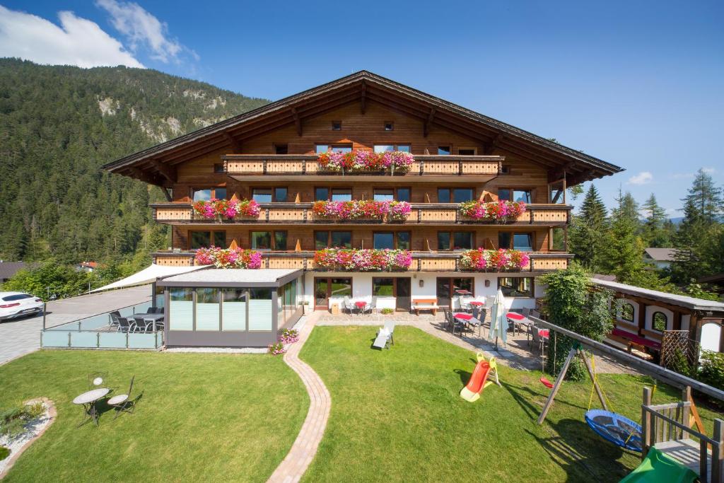 een groot huis met een speeltuin ervoor bij Das ALPSPITZ in Biberwier