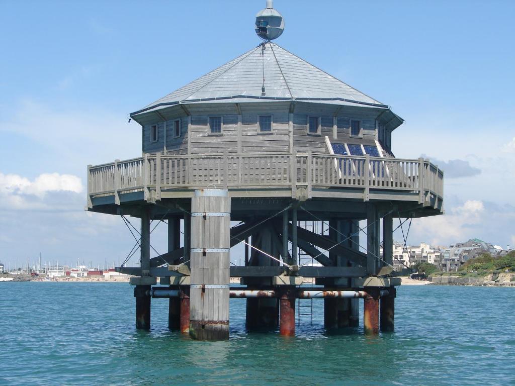 un faro de madera sobre el agua en el océano en T2 Agréable, en Rochefort