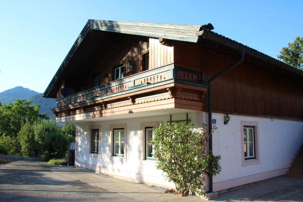 a large white building with a tree in front of it at Ferienwohnung Seilbahn in Sankt Gilgen