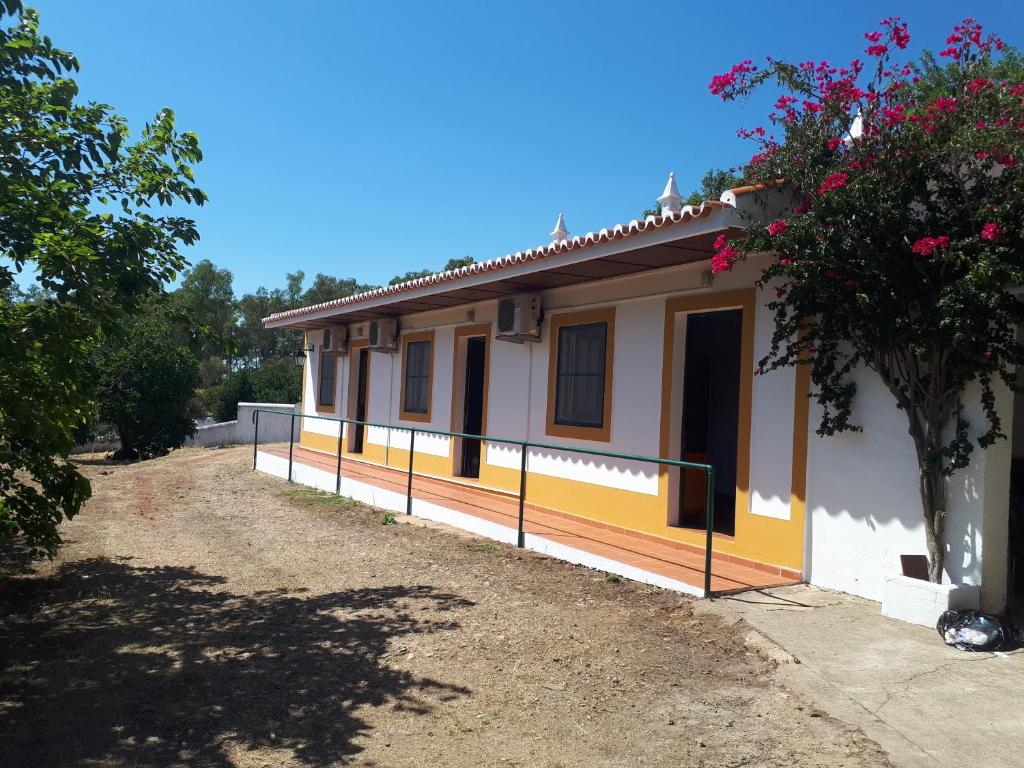 une petite maison jaune et blanche avec un arbre dans l'établissement Palacete Dos Alcaides, à Mine de São Domingos