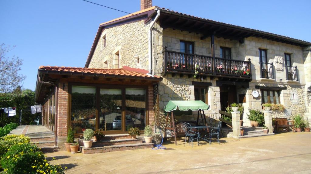 een gebouw met een tafel en een paraplu ervoor bij Posada Herrán in Santillana del Mar