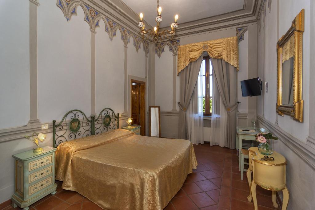 een slaapkamer met een bed, een tafel en een raam bij Hotel Villa Cheli in Lucca