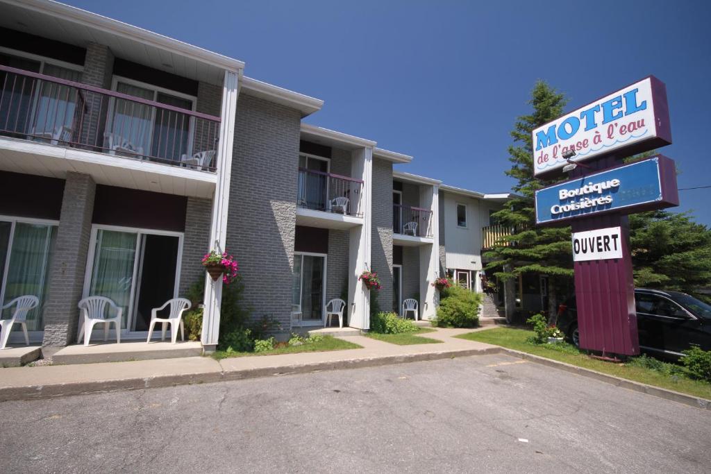 un cartello di un motel di fronte a un edificio di Motel de l'Anse a l'Eau a Tadoussac