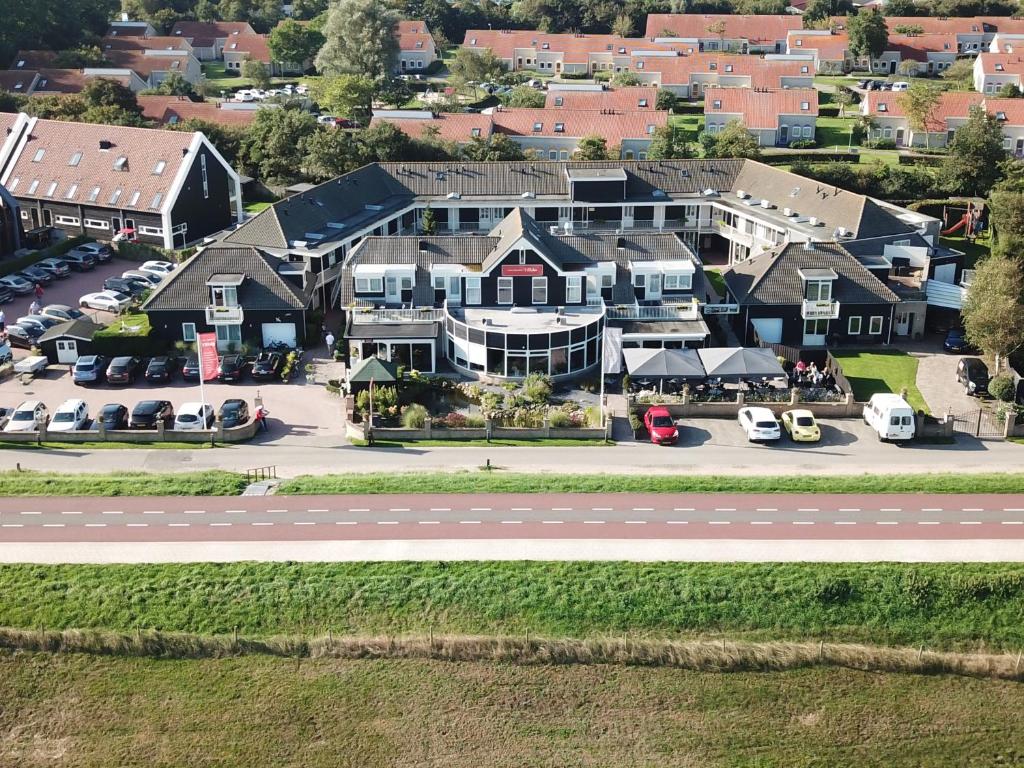 een luchtzicht op een groot huis met een parkeerplaats bij Hotel Restaurant 't Klokje in Renesse