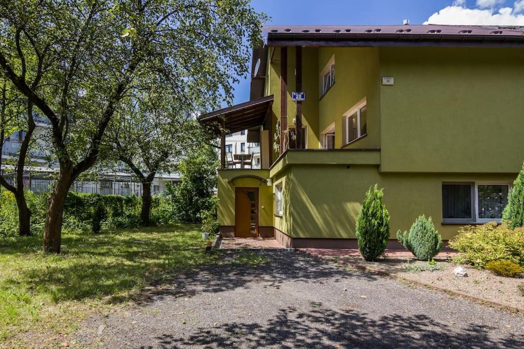 ein grünes Haus mit einer Einfahrt davor in der Unterkunft Parkowa House in Krakau