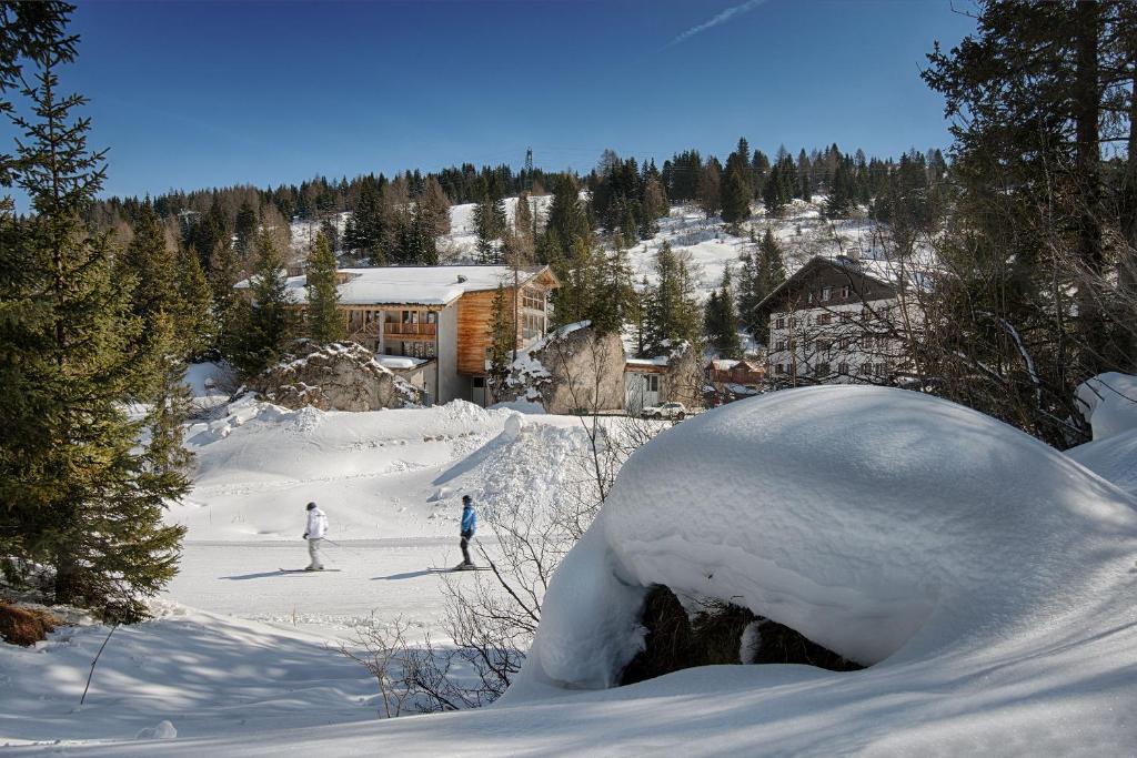 un par de personas esquiando por una pista cubierta de nieve en Hotel Garni Elisir, en Arabba