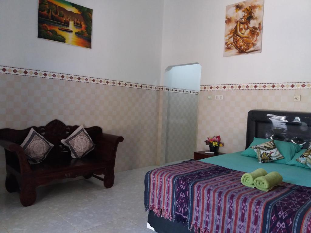 um quarto com uma cama e uma cadeira em citiz house & hostel em Nusa Penida