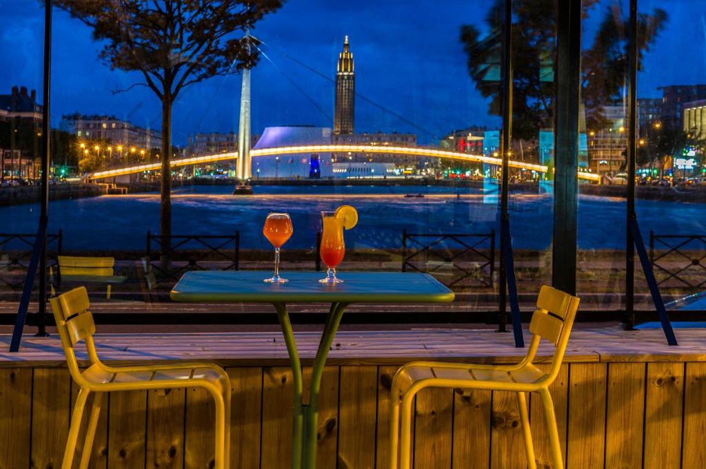 una mesa y dos sillas con dos vasos. en Mercure Le Havre Centre Bassin Du Commerce, en Le Havre