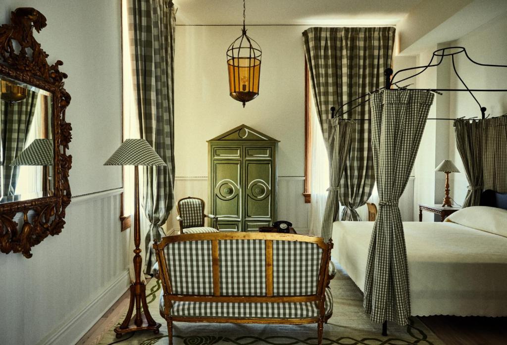 una camera con letto, sedia e specchio di Hotel Peter and Paul, an Ash Hotel a New Orleans