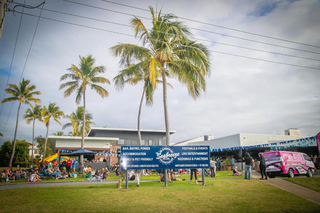 un cartello in un parco con palme e persone di Mackay Seabreeze Apartments a Mackay