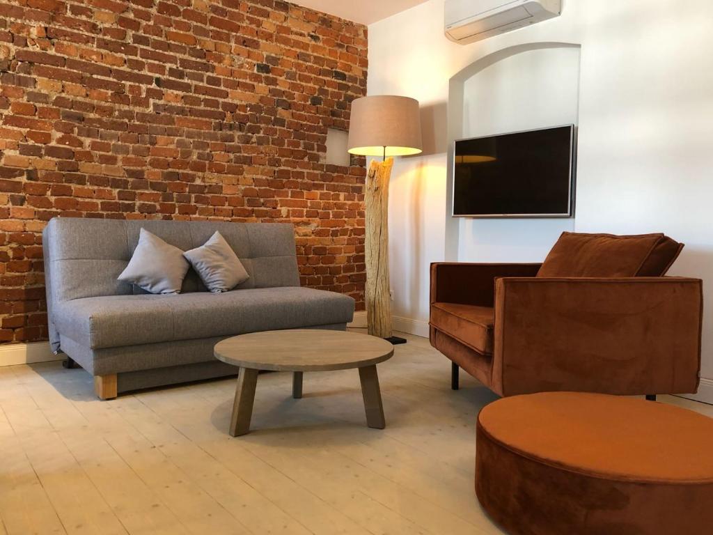 uma sala de estar com um sofá e uma cadeira em VIA`s Appartements und Ferienwohnungen em Görlitz