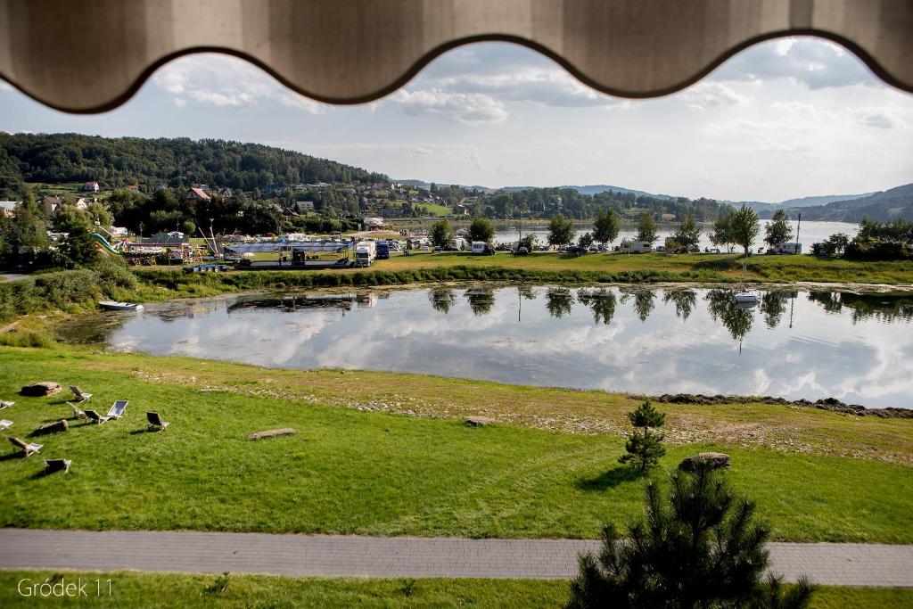 vistas a un estanque con ovejas en un campo en Apartment Słoneczny Gródek 11, en Gródek Nad Dunajcem