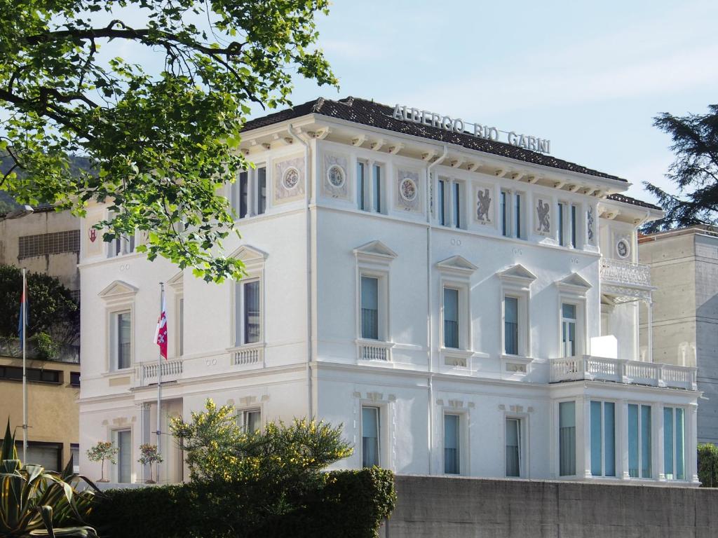 una casa bianca con una bandiera di Hotel Rio Muralto a Locarno