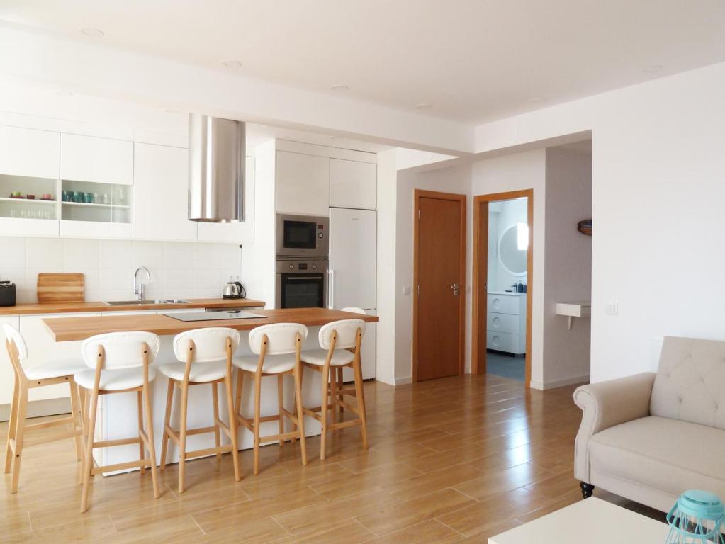 uma cozinha e sala de estar com mesa e cadeiras em Ocean Breeze Apartment em Estoril