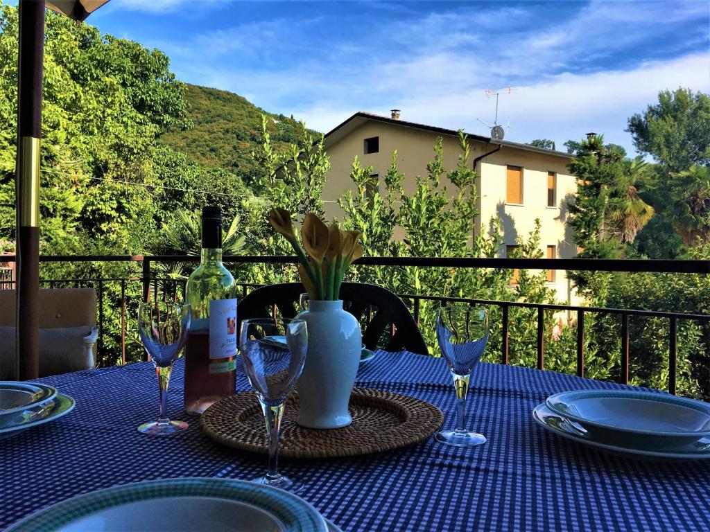 einen Tisch mit einem blauen Tischtuch und einer Flasche Wein in der Unterkunft Casa al vecchio mulino in Negrar