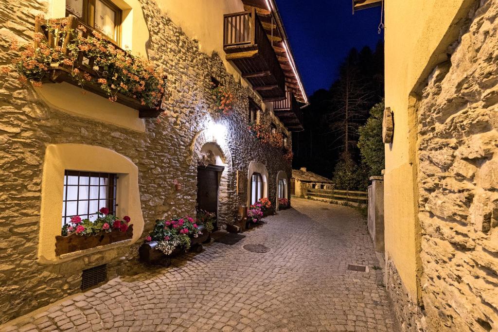 eine Gasse mit Blumenkästen an der Seite eines Gebäudes in der Unterkunft Etoile des Neiges in Sauze dʼOulx