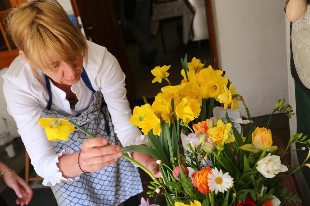 Eine Frau macht einen Blumenstrauß in der Unterkunft Bräustüberl Schönbrunn - Hotel & Restaurant in Wunsiedel