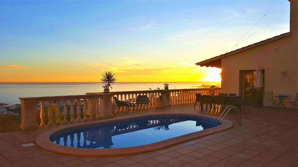 - une piscine sur un balcon avec vue sur le coucher du soleil dans l'établissement Ashram Villa Sunshine, à Sitges