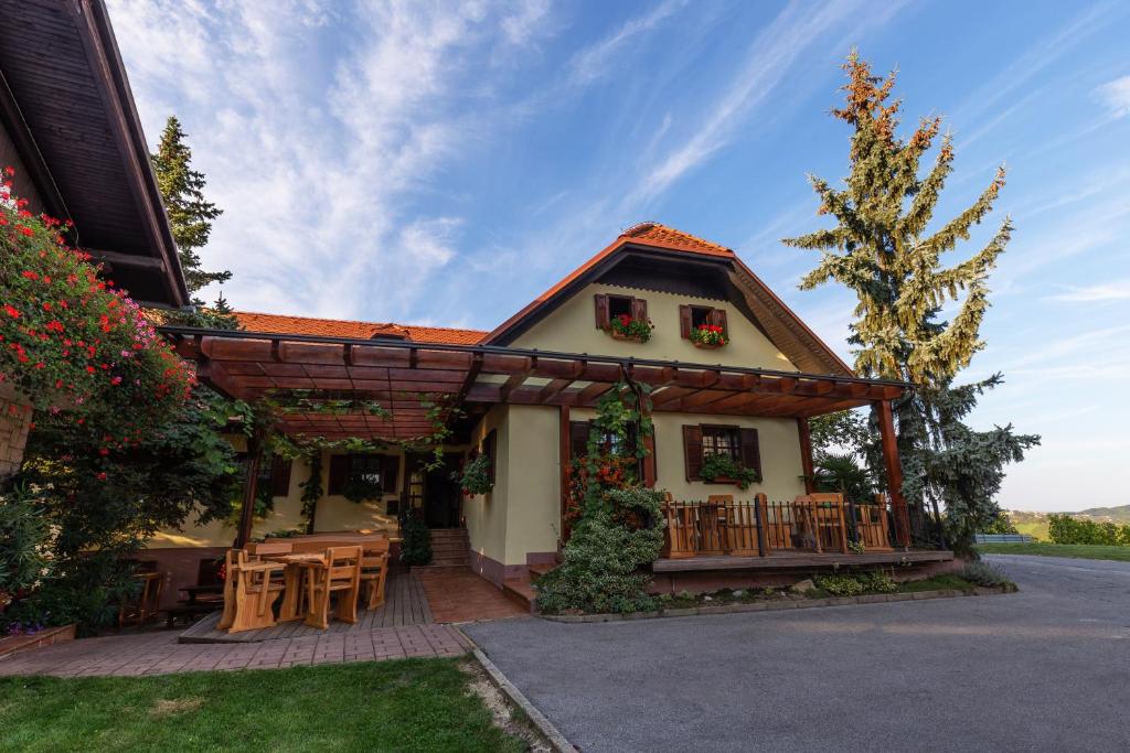 een huis met een veranda met een tafel en stoelen bij Turistična Kmetija Pungračič in Zavrč