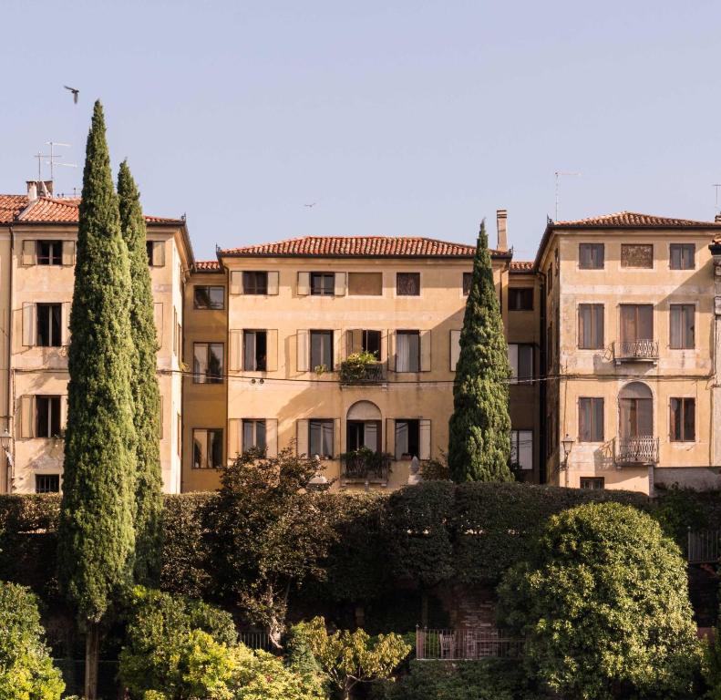 um grupo de edifícios com árvores à sua frente em Le 33 em Bassano del Grappa