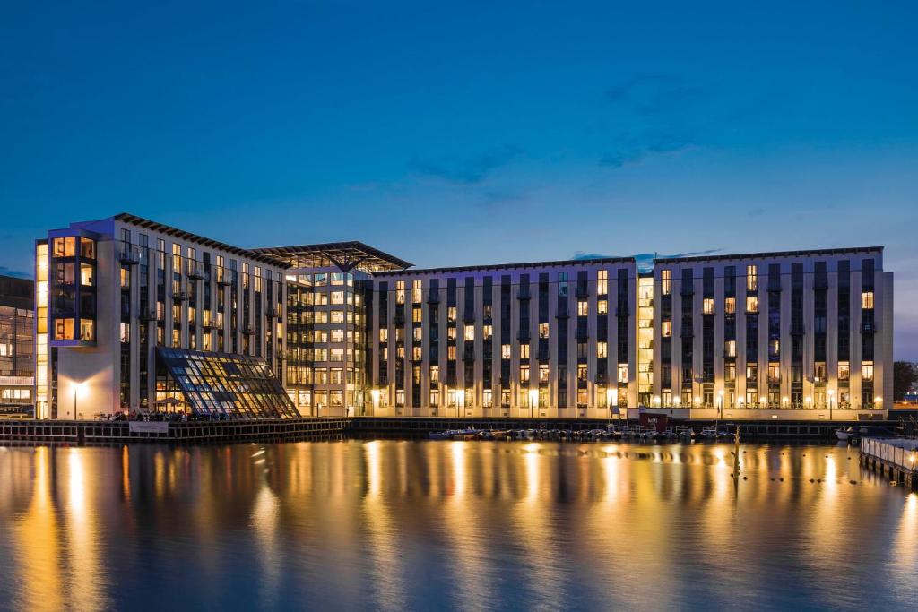 ein großes Gebäude am Wasser in der Nacht in der Unterkunft Copenhagen Island Hotel in Kopenhagen