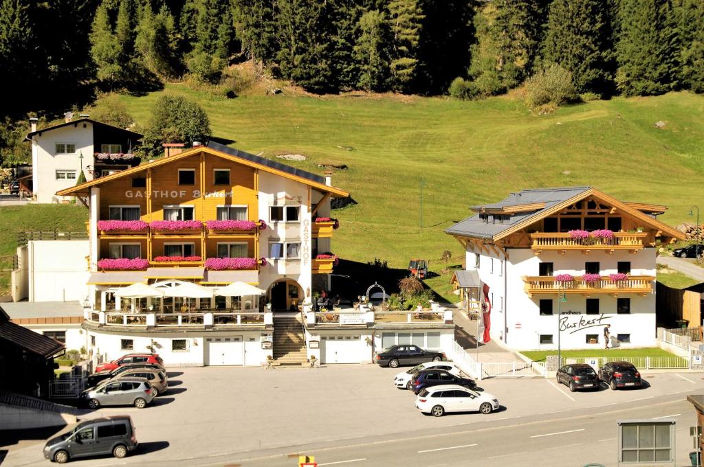 a large building with cars parked in a parking lot at Gasthof Burkert in Oetz