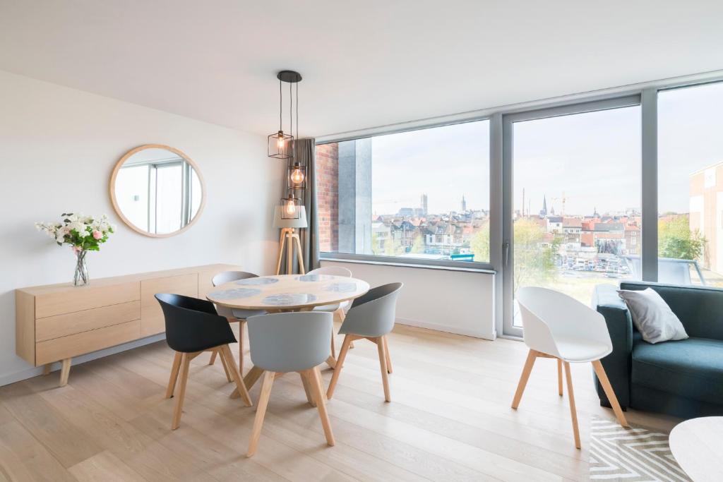 a living room with a table and chairs and a couch at Skyline Flats Gent in Ghent