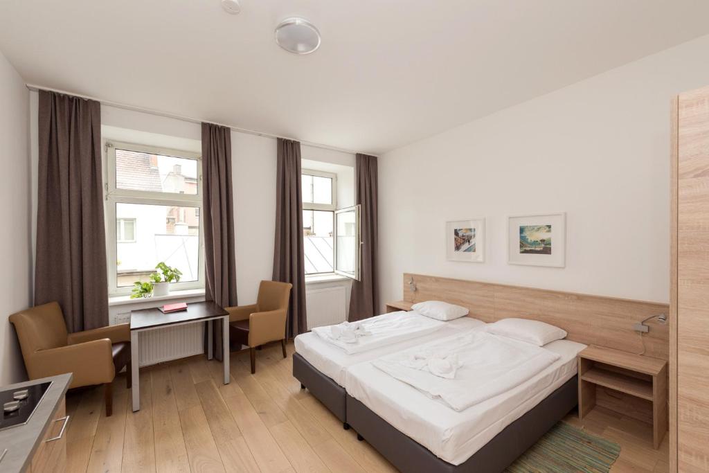 1 dormitorio con 1 cama, escritorio y sillas en Metro Apartments Vienna, en Viena