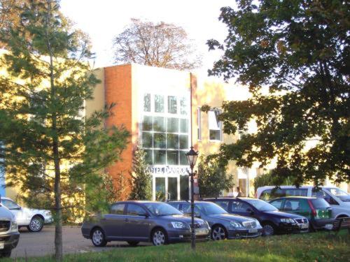 um grupo de carros estacionados em frente a um edifício em Hotel Dänholm em Stralsund