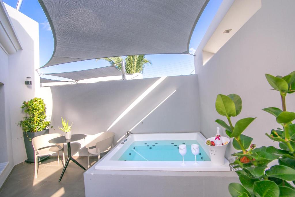 - un bain à remous intérieur dans une pièce avec fenêtre dans l'établissement Marquise Suites - Adults Only, à Fira