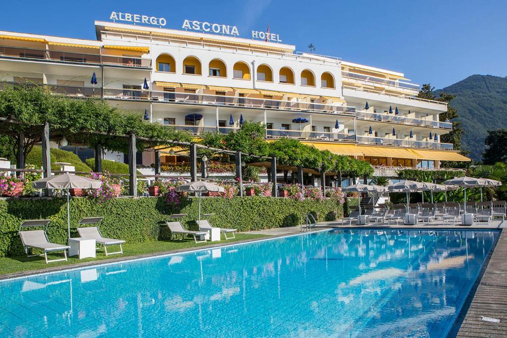 ein Hotel mit einem Pool vor einem Gebäude in der Unterkunft Hotel Ascona in Ascona