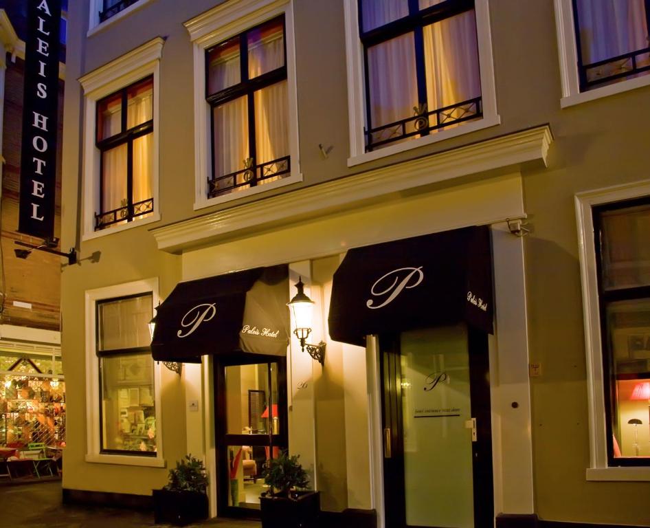 een winkel voor een gebouw met paraplu's bij Paleis Hotel in Den Haag