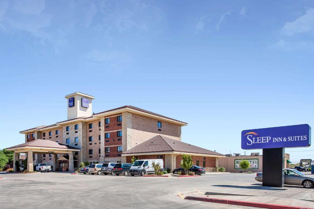 un bâtiment avec un panneau en face d'un parking dans l'établissement Sleep Inn & Suites, à Lubbock