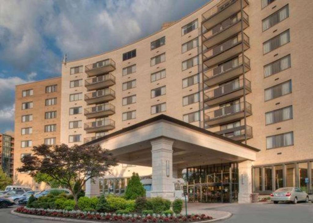 a large building with a parking lot in front of it at Clarion Collection Hotel Arlington Court Suites in Arlington