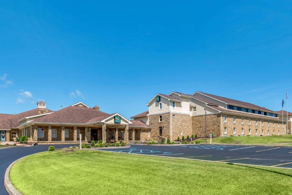 un grand bâtiment avec une pelouse devant lui dans l'établissement Quality Inn & Suites Bedford West, à Bedford