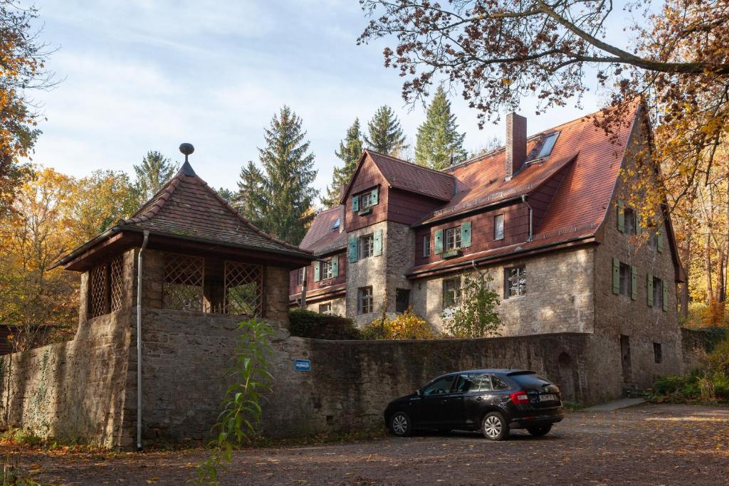 een auto geparkeerd voor een groot huis bij Alte Falknerei in Weimar