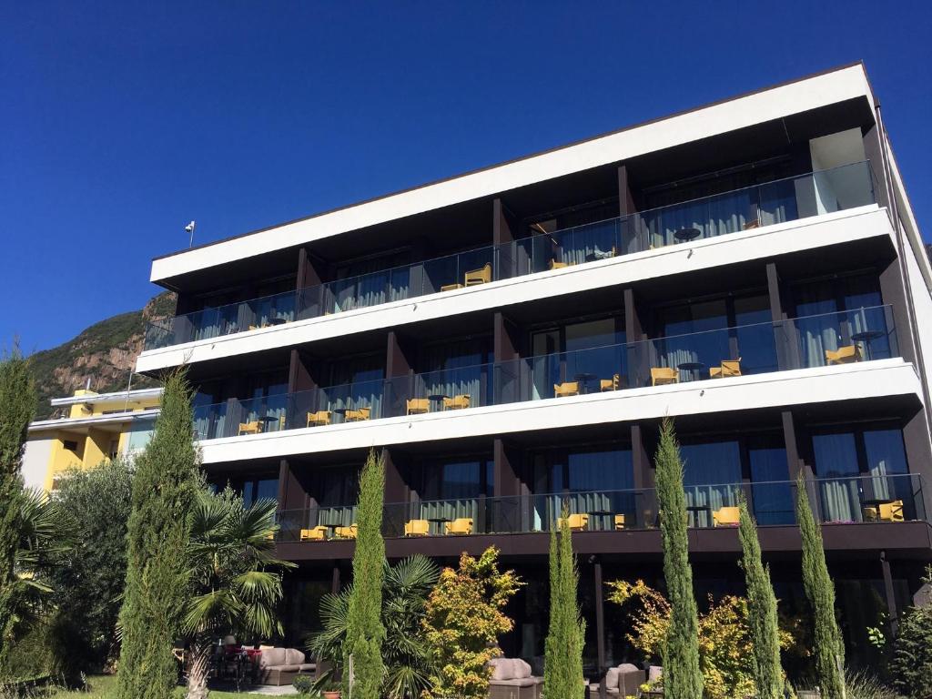 un grande edificio bianco con tavoli e sedie di Hotel Raffl a Bolzano