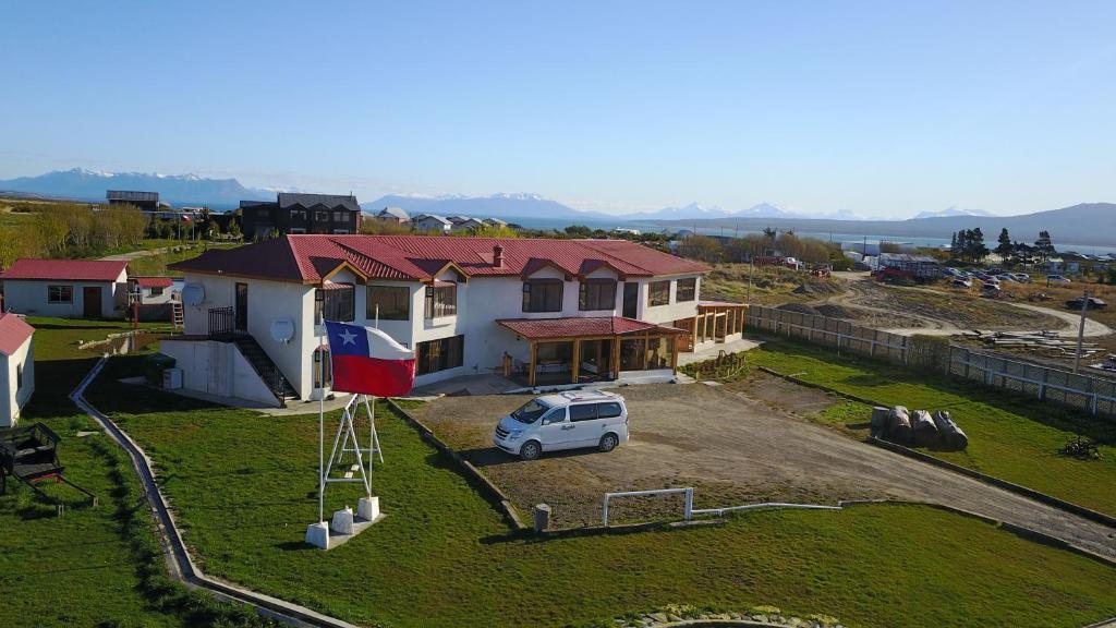 une camionnette blanche garée devant une maison dans l'établissement Hostal Doble E Patagonia, à Puerto Natales