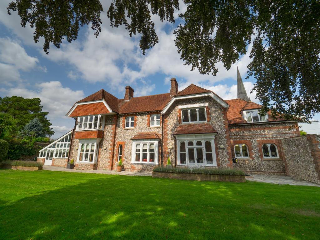 una gran casa de ladrillo con césped verde en 4 Canon Lane, en Chichester