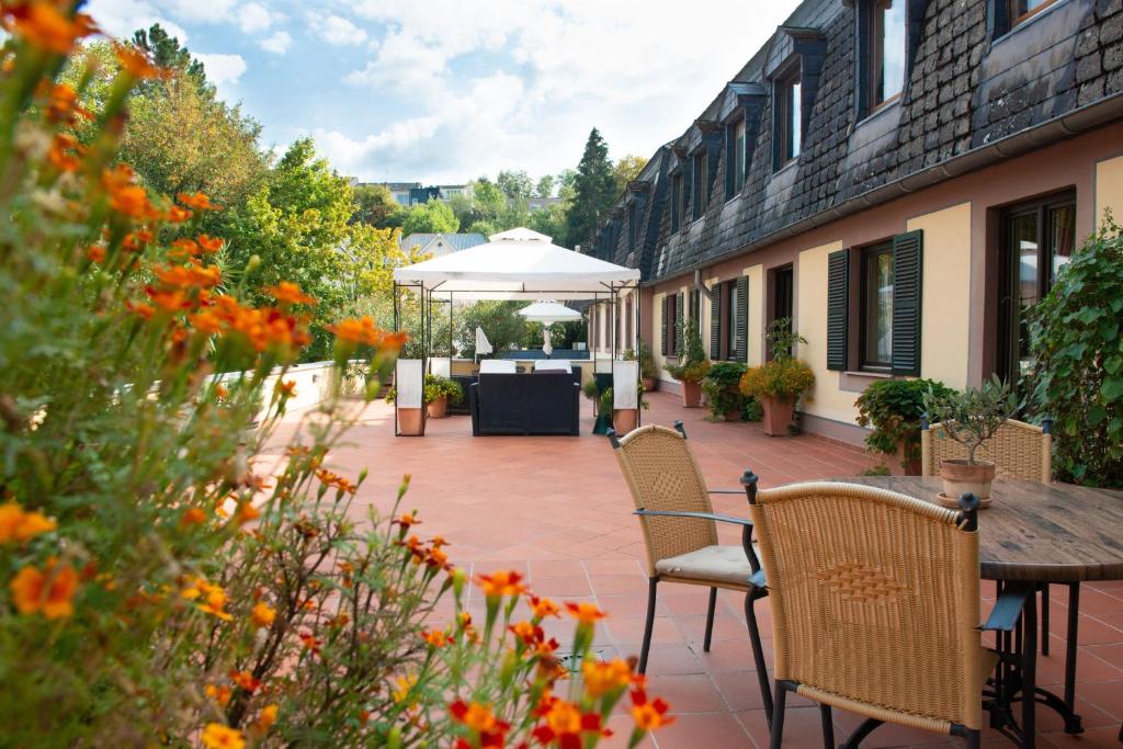 a patio with chairs and a table and an umbrella at Blesius Garten in Trier