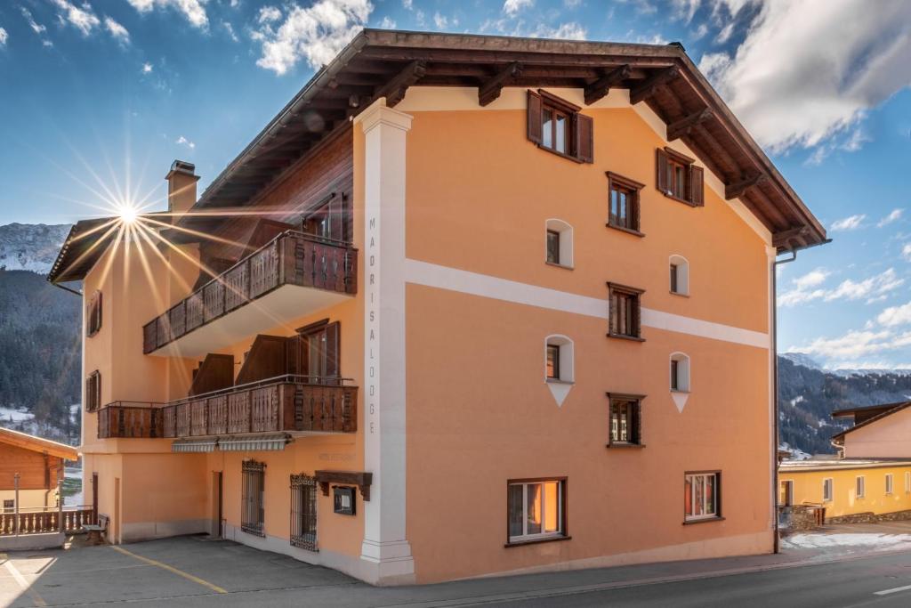 - un bâtiment avec un balcon sur le côté dans l'établissement Madrisa Lodge, à Klosters