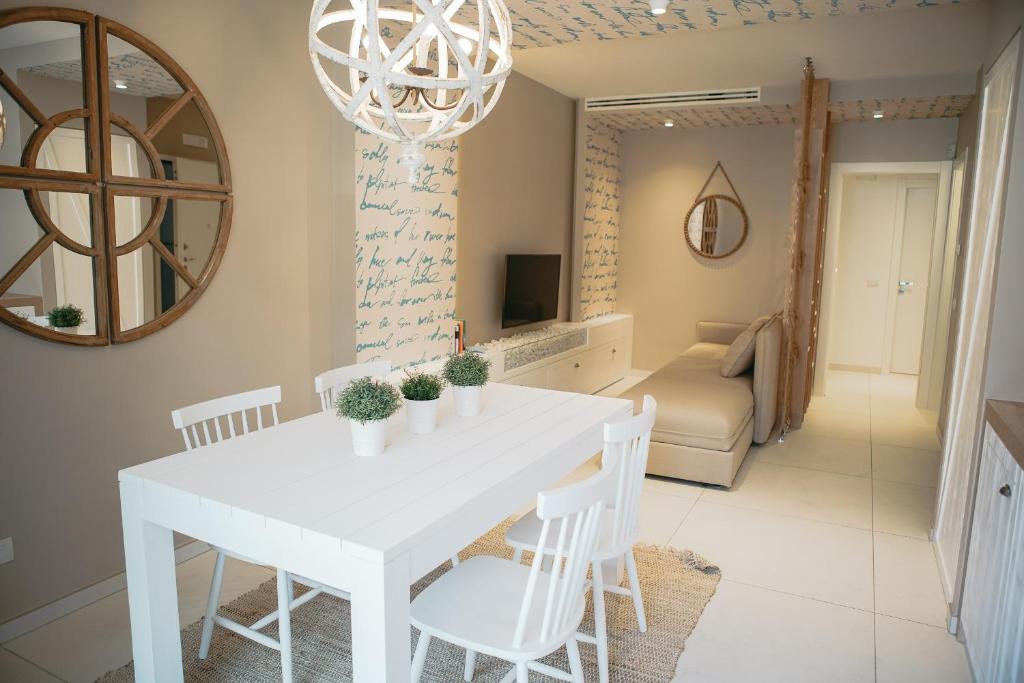 a white dining room with a white table and chairs at Terradamare in Monopoli