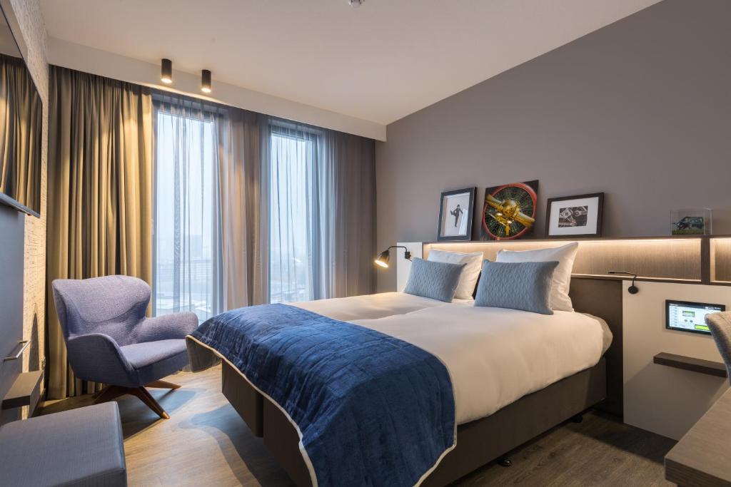 Postillion Hotel Amsterdam tesisinde bir odada yatak veya yataklar