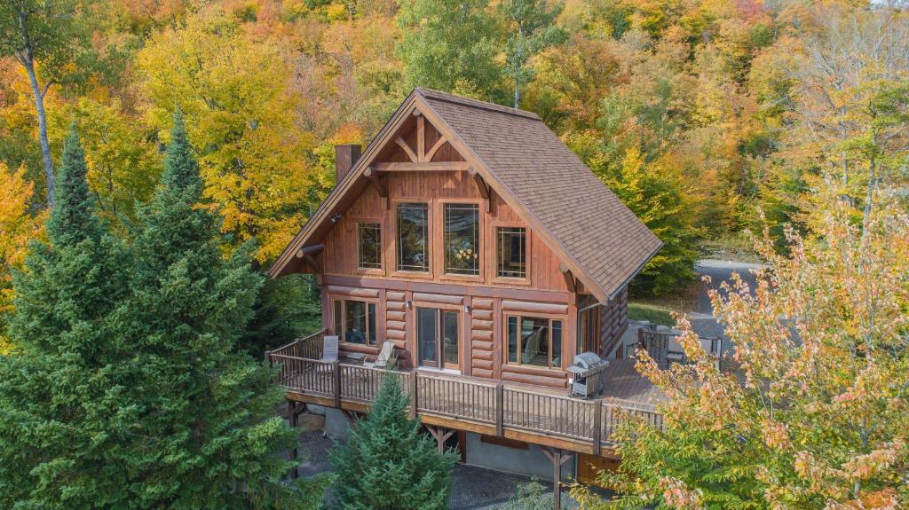 eine Aussicht über eine Blockhütte im Wald in der Unterkunft Log Cabin Home with Lake and Mountain view by Reserver.ca in Sainte-Adèle