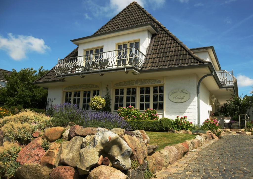 uma casa com uma cerca de pedra em frente em Hotel garni Seeluft Büsum em Büsum