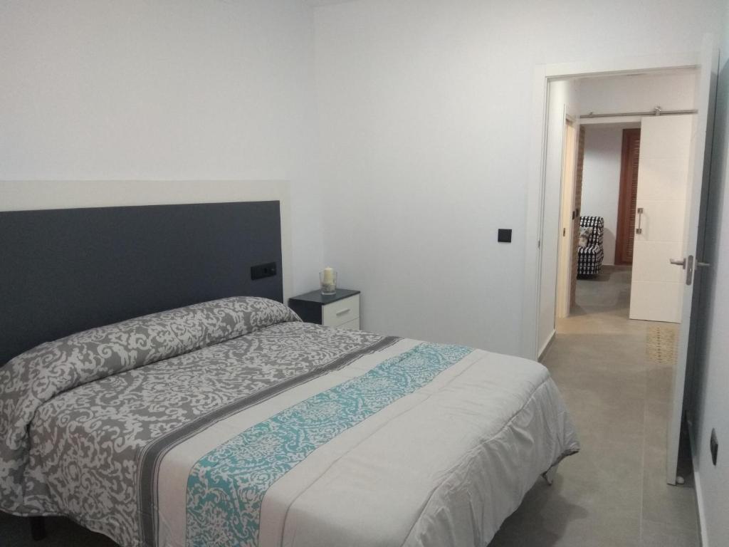 um quarto com uma cama e uma porta para um corredor em Caleros 8 Apartamento - Apartamentos de la Parte Antigua de Cáceres em Cáceres